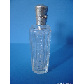 an antique crystal perfume bottle with silver top