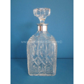 a crystal cut decanter with silver mounts