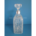 a crystal cut decanter with silver mounts