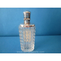 een antiek glazen parfumflacon met zilveren dop en front