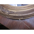 an antique oval gilt mirror