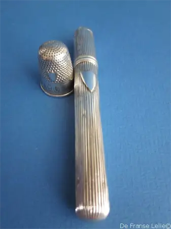 een antiek Hollands zilveren naaldenkoker inclusief bijpassende vingerhoed