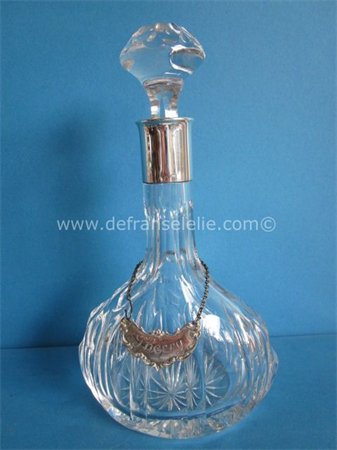 a crystal carafe with silver mounting