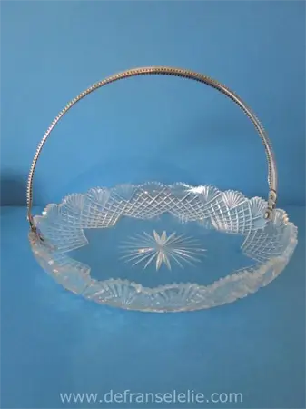 een antiek kristallen koekschaal met zilveren hengsel