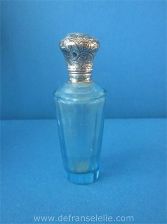 an antique French glass perfume bottle with silver top