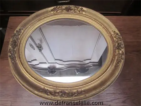 an antique oval gilt mirror