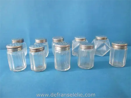 a small collection of vintage glass salts with silver top