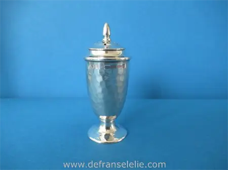 an antique sterling silver hammered pepper caster
